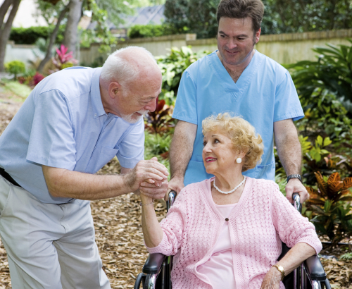 Elderly woman in wheel chair with nurse and elderly men
